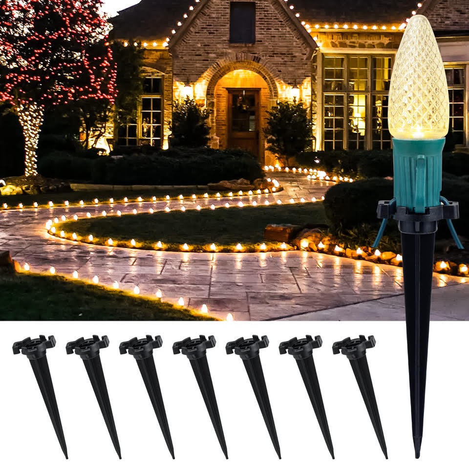 Stake lighting example A display of light stakes and a Christmas bulb beside a decorated house and path.